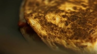 Kızartma tavasında taze sarılmış tavuk quesadilla kızartıyorum. Örtüyü çıkarıyorum. Meksika usulü quesadillas yapma süreci. Makro görünüm