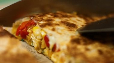 Tahta kesme tahtasıyla taze kızarmış tavuklu quesadilla kesmek. Meksika usulü quesadillas yapma süreci. Makro görünüm