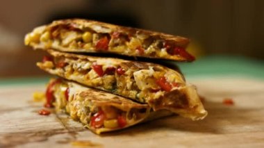 Tahta kesme tahtasının üzerinde taze kızarmış tavuk Quesadilla 'sı. Meksika usulü quesadillas yapma süreci