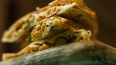 Tahta kesme tahtasının üzerinde taze kızartılmış sebzeli quesadilla. Meksika usulü quesadillas yapma süreci. Makro görünüm