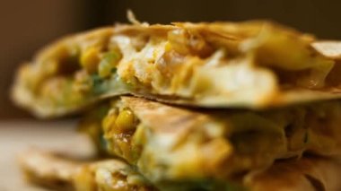 Tahta kesme tahtasının üzerinde taze kızartılmış sebzeli quesadilla. Meksika usulü quesadillas yapma süreci. Makro görünüm, yavaş çekim