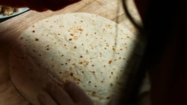 Mehltortilla mit geriebenem Käse füllen. Prozess der Herstellung mexikanischer Quesadillas mit Käse und Gemüse. Künstlerisches Schießen — Stockvideo