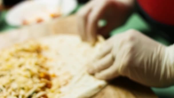 Reszelt sajttal és zöldségekkel töltött liszttortilla csomagolása. Mexikói quesadillák készítésének folyamata — Stock videók