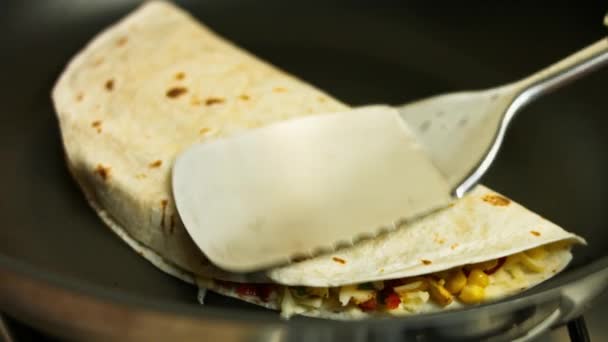 Τηγανίζοντας ένα φρεσκοκομμένο κοτόπουλο κεσαντίγια σε ένα τηγάνι. Διαδικασία παρασκευής μεξικανικών quesadillas — Αρχείο Βίντεο