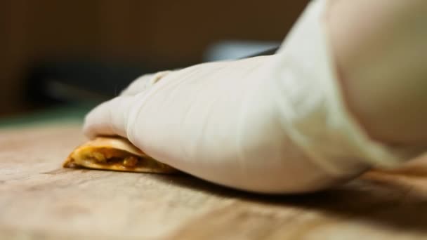 Cortar una quesadilla de verduras recién fritas en una tabla de cortar de madera. Proceso de hacer quesadillas mexicanas. Vista macro — Vídeos de Stock