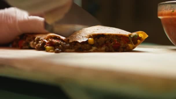 Frissen sült marhahúsos quesadillát szeletelek egy fából készült vágódeszkán. Mexikói quesadillák készítésének folyamata. Oldalnézet — Stock videók