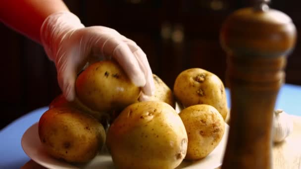 Mãos femininas descascando uma batata com descascador em uma cozinha. Processo de cozinhar batatas assadas forno perfeito. — Vídeo de Stock