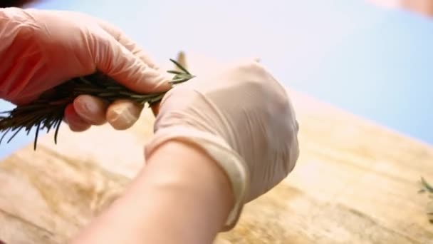 Γυναικεία χέρια που αφαιρούν φύλλα από ένα φρέσκο κλαδί δεντρολίβανου. Διαδικασία μαγειρέματος τέλειας ψητής πατάτας φούρνου. Καλλιτεχνική σκοποβολή — Αρχείο Βίντεο