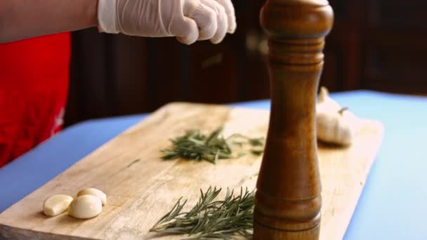 Samičí ruce odstraňující listy z čerstvé větvičky rozmarýnu. Proces vaření perfektní pece pečené brambory — Stock video