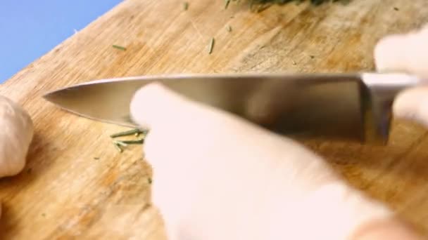 Mâinile de sex feminin taie frunze proaspete dintr-o crenguță de rozmarin pe o placă de tăiere din lemn. Procesul de gătire a cartofilor prăjiți perfect cuptor. Fotografie artistică — Videoclip de stoc