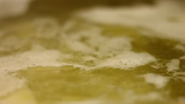 鍋にお湯で沸騰した黄金のジャガイモ。完璧なオーブンローストポテトを調理するプロセス — ストック動画