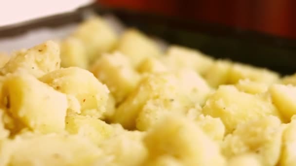 Τακτοποιήστε βραστές χρυσές πατάτες καρυκεύματα με λάδι, αλάτι και μαύρο πιπέρι σε ένα ταψί. Διαδικασία μαγειρέματος τέλειας ψητής πατάτας φούρνου. Μακροσκοπική προβολή — Αρχείο Βίντεο