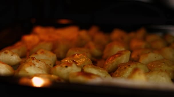 Patatas doradas hervidas con aceite, sal y pimienta negra asadas en el horno. Proceso de cocción de patatas asadas al horno perfecto — Vídeo de stock