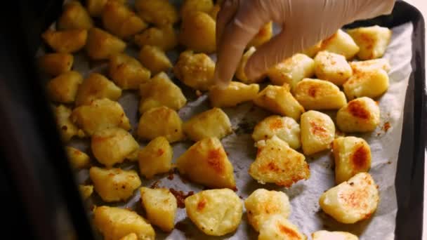 Draai de geroosterde gouden aardappelen gekruid met olie, zout en zwarte peper op een bakpan. Proces van het koken van perfecte oven geroosterde aardappelen — Stockvideo