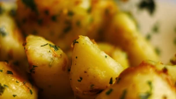 Batatas douradas assadas temperadas com alho frito e alecrim e salsa fresca. Processo de cozinhar batatas assadas forno perfeito. Vista macro — Vídeo de Stock