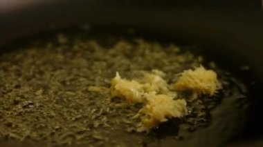 Kızartma tavasında acı yağda doğranmış biberiye yapraklarına ince rendelenmiş sarımsak ekliyorum. Fırında kızartılmış patates pişirme işlemi.