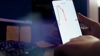 Akıllı telefondan şifreli para grafiği analiz edilirken kan basıncını ölçmek ve çay içmek. Borsada BTC 'den alıntılar. Akıllı telefonun ekranındaki uygulamayı görüntüle