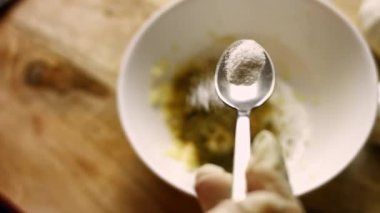 Kadın şeflerin elleri bir kaseye bir tutam sarımsak ezmesine tuz ekliyor. Baharatları sosa hazırlıyorum. Pişirme işlemi shkmeruli - Gürcü yemeği