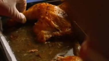 Kadın aşçı fırında kavrulmuş büyük bir tavuğu fırın tepsisine oyuyor. Pişirme işlemi shkmeruli - Gürcü yemeği