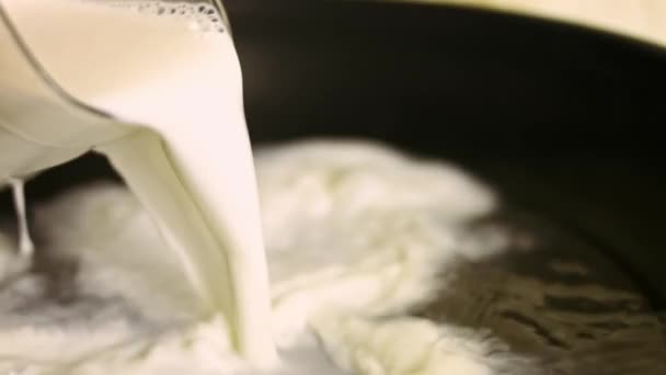 Chef hembra vertiendo un vaso de leche en una sartén. Preparando la salsa para el pollo. Proceso de cocción shkmeruli - plato georgiano — Vídeos de Stock