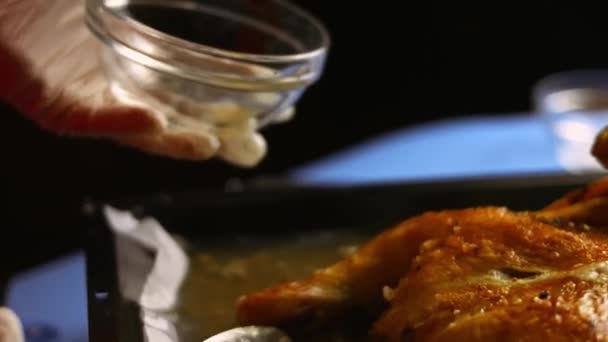 Köchin sammelt geschmolzenes Fett aus einem großen Spatchcocks Ofen gebratenes Hühnchen auf einem Backblech. Prozess des Kochens shkmeruli - georgisches Gericht. Kunstschuss — Stockvideo
