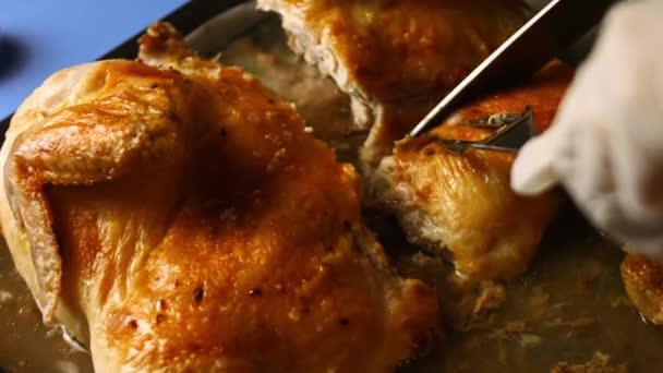 Eine Köchin schnitzt auf einem Backblech ein großes, im Ofen gebratenes Hühnchen. Prozess des Kochens shkmeruli - georgisches Gericht — Stockvideo