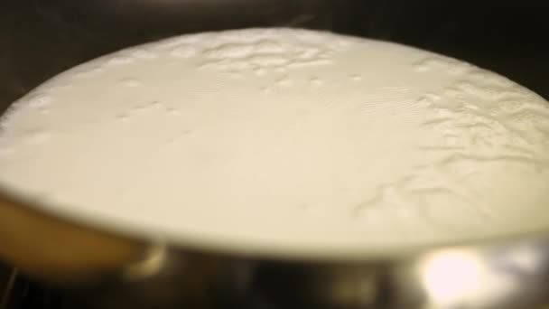 Milch und Wasser in einer Pfanne zum Kochen bringen. Die Sauce für das Huhn zubereiten. Prozess des Kochens shkmeruli - georgisches Gericht — Stockvideo