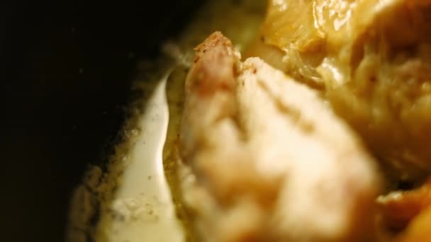 Горячая свежеприготовленная большая печь жареная курица, тушеная в пряном соусе в сковороде. Кто-то макает мягкий кусок хлеба в соус. Шкмерули - грузинское блюдо. Макровзгляд — стоковое видео