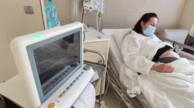 Kemerlerin karnındaki hamile kadın fetüs testini izliyorum. Hastanede Sağlık Teşhisi