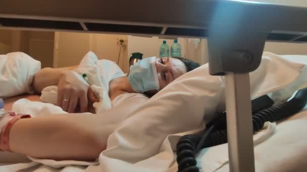 La madre amamanta a un bebé recién nacido en un hospital moderno en una cuna de hospital. Lactancia materna en las primeras horas después del nacimiento, la mujer acaricia al bebé recién nacido. Momento emocional en hermosa iluminación — Vídeo de stock