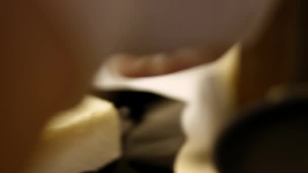 La mantequilla se derrite chisporroteando en la sartén en la estufa. De cerca. — Vídeo de stock