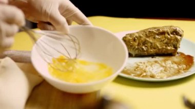 Eller çırpılmış yumurtayla Wellington usulü çiğ sığır etinin yakınına kase koyar. 4k video