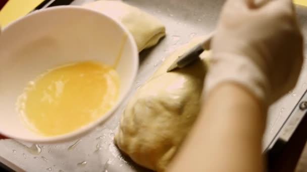 Ręce wkładają miskę z ubitym jajkiem blisko uformowanej surowej wołowiny Wellington. 4k wideo — Wideo stockowe