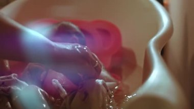 Yeni doğmuş bebek. Yedi günlük. Suda Banyo. 4K video romantik arkadaş çevresi. Güzel duygular.