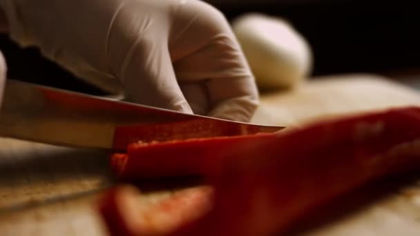 Corte de pimentão vermelho fresco do sino na placa de corte de madeira. Fecha. 4k vídeo — Vídeo de Stock
