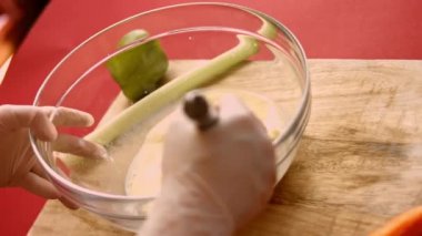 Taze yumurta, un ve sütü cam bir kasede çelik elle karıştırmanın makro görüntüsü. Krep hazırlama süreci. 4K görüntü yönetmeni videosu