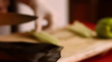 Şef, kereviz sebzesini tahta kesme tahtasıyla keser. Ellerinizi kapatın. 4k sinematografi tarifi
