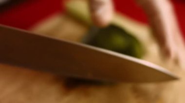 Yakından bakan adamlar yeşil biberi keskin bıçakla kesiyorlar. Şef yeşil tatlı kırmızı biber kesiyor. Sağlıklı gıda konsepti. Sebzeleri salataya hazırlıyorum. Yüksek kalite 4k video.