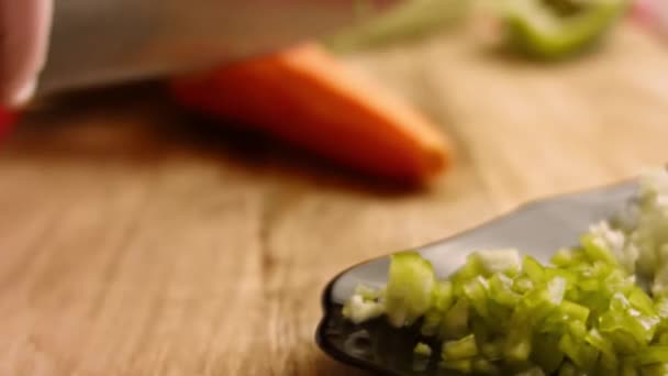Ο σεφ κόβει καρότα για σαλάτα με κοφτερό μαχαίρι. Αρσενικό σεφ ετοιμάζει σαλάτα στην κουζίνα στο σπίτι. Μαγειρεύω ένα νόστιμο γεύμα στην κουζίνα του εστιατορίου. Προετοιμασία των συστατικών. Υγιεινή διατροφή κάθε μέρα — Αρχείο Βίντεο