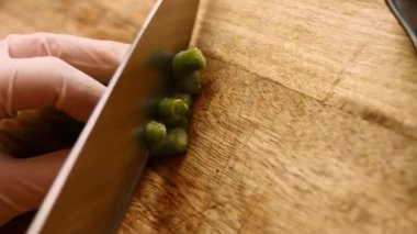 Kadın elleri piattoni kesiyor. Donmuş yeşil fasulye yakından geliyor. 4k sinematografi videosu