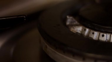 Siyah arka planda fırın ocağını açıyorum. Mutfak ocağı açılıyor. Ateşe yaklaş. Soba ocağında doğal gaz iltihabı, yakın görüş. Mutfak gaz sobasından gaz yanıyor.