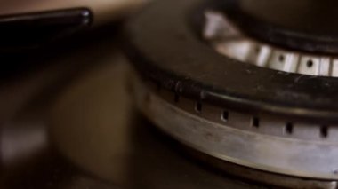 Siyah arka planda fırın ocağını açıyorum. Mutfak ocağı açılıyor. Ateşe yaklaş. Soba ocağında doğal gaz iltihabı, yakın görüş. Mutfak gaz sobasından gaz yanıyor.