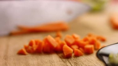 Şef salata için keskin bir bıçakla havuç keser. Erkek şef evde mutfakta salata hazırlıyor. Restoranın mutfağında lezzetli bir yemek pişirmek. Malzemelerin hazırlanması. Her gün sağlıklı yemek.