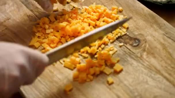 Snijd de cheddar kaas in stukken. 4k video recept — Stockvideo