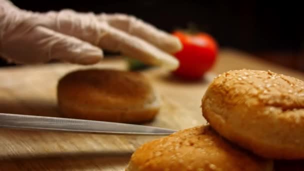 Snijd het brood voor de hamburger in twee delen. Lekkere Low-Calorie Groene Burgers. Voedsel voor nieuwe moeders. 4k video recept — Stockvideo