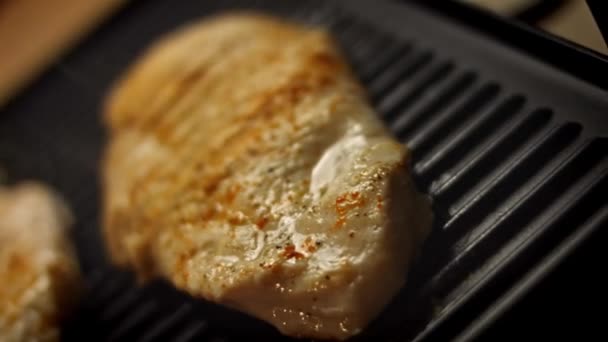 Lahodný šťavnatý masový steak na grilu. Vařit grilování čerstvý kuřecí prsa. Smažené kuřecí řízečky na elektrické pražírně. Nalijte sůl, rozmarýn, černý pepř. Video 4k — Stock video