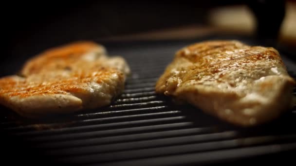 Delicioso bife de carne suculento cozinhando na grelha. Cozinhe grelhar peito de frango fresco. Filé de frango frito na torradeira elétrica. Despeje sal, alecrim, pimenta preta. 4k vídeo — Vídeo de Stock