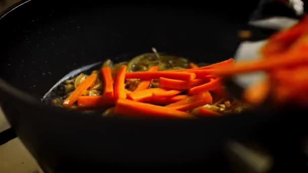 Die Möhre zu der gebratenen Zwiebel geben. 4k-Video — Stockvideo