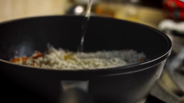 Añadir agua al pilaf. Vídeo 4k — Vídeos de Stock