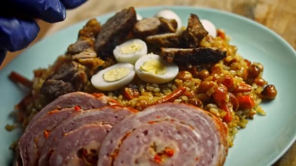 Coloquei o pilaf uzbeque no prato. Decore bem com carne cortada. 4k vídeo — Vídeo de Stock